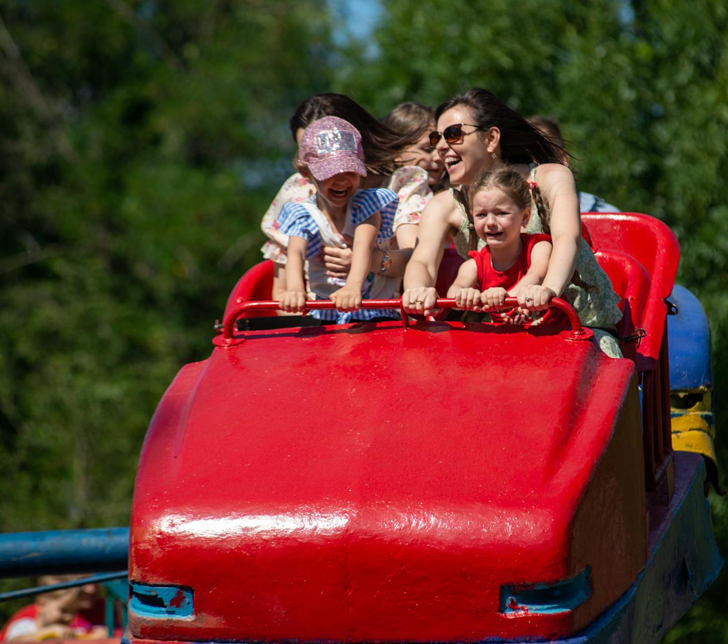 Happy family enjoying a day at an Orlando theme park with rides in the background