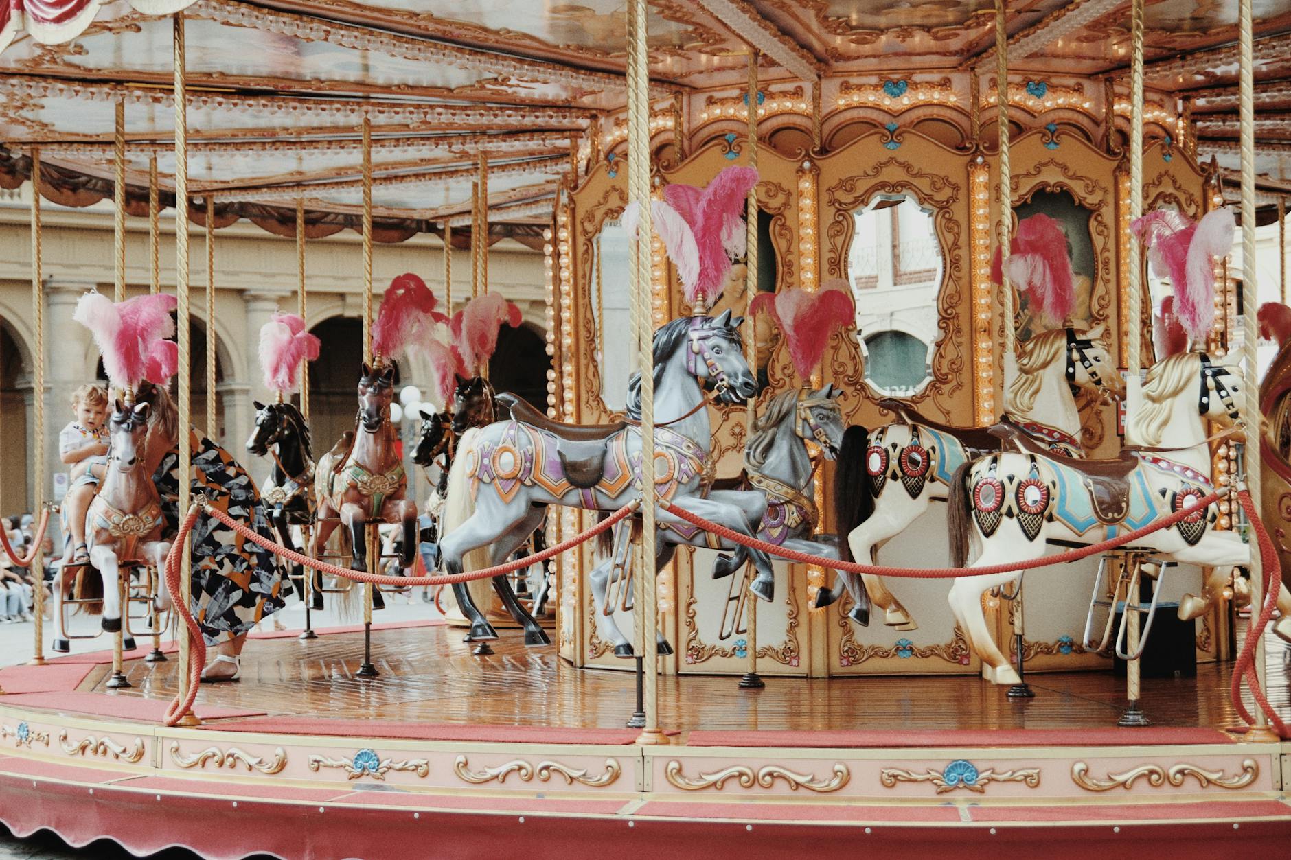 Young children riding a vintage carousel at a theme park