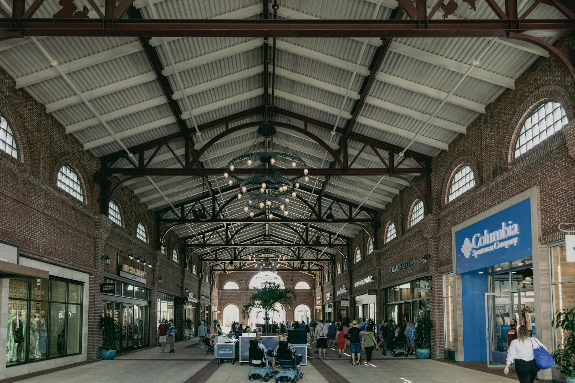 Shoppers walking through an open-air Orlando outlet mall on a sunny day