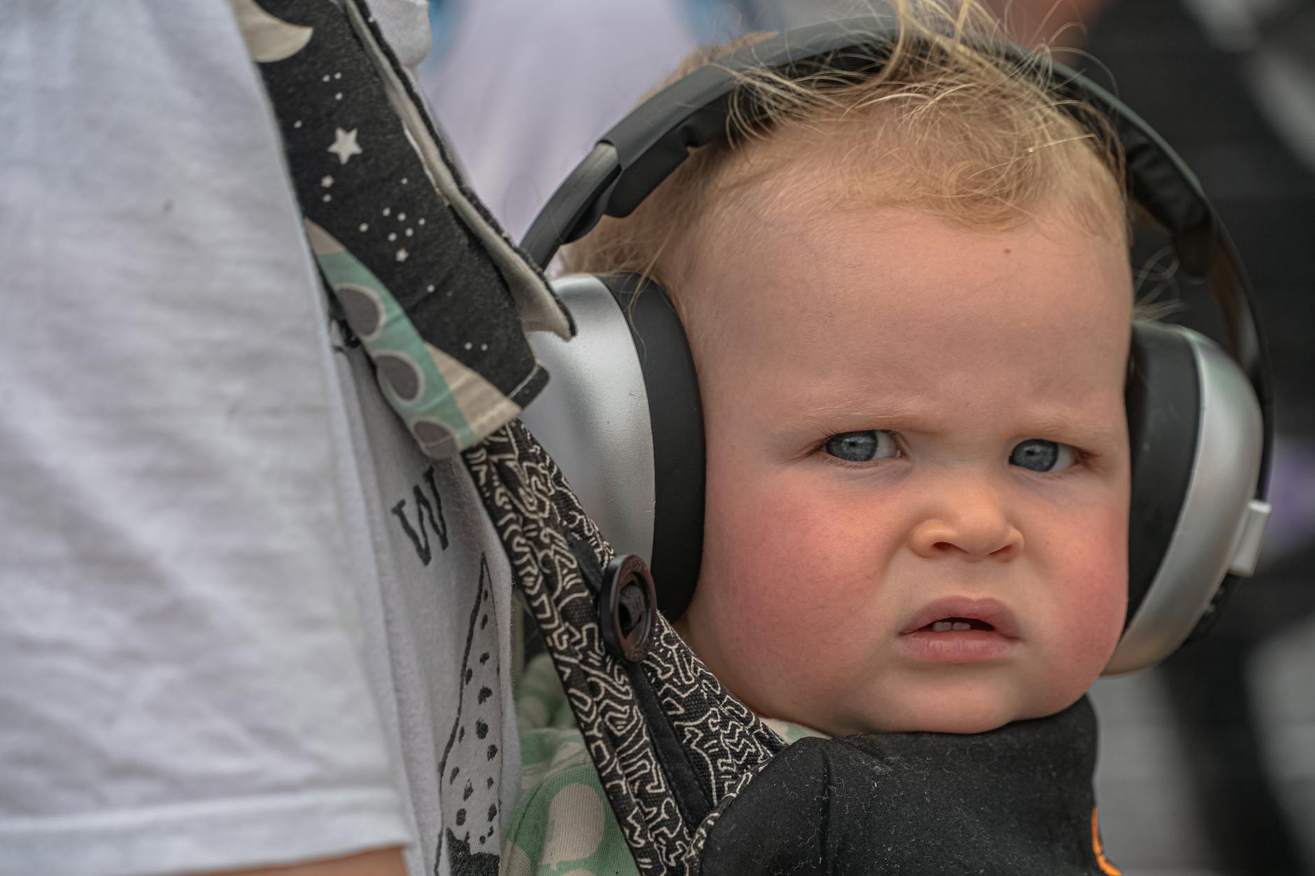 Child wearing noise-reducing headphones to manage sensory input at a theme park
