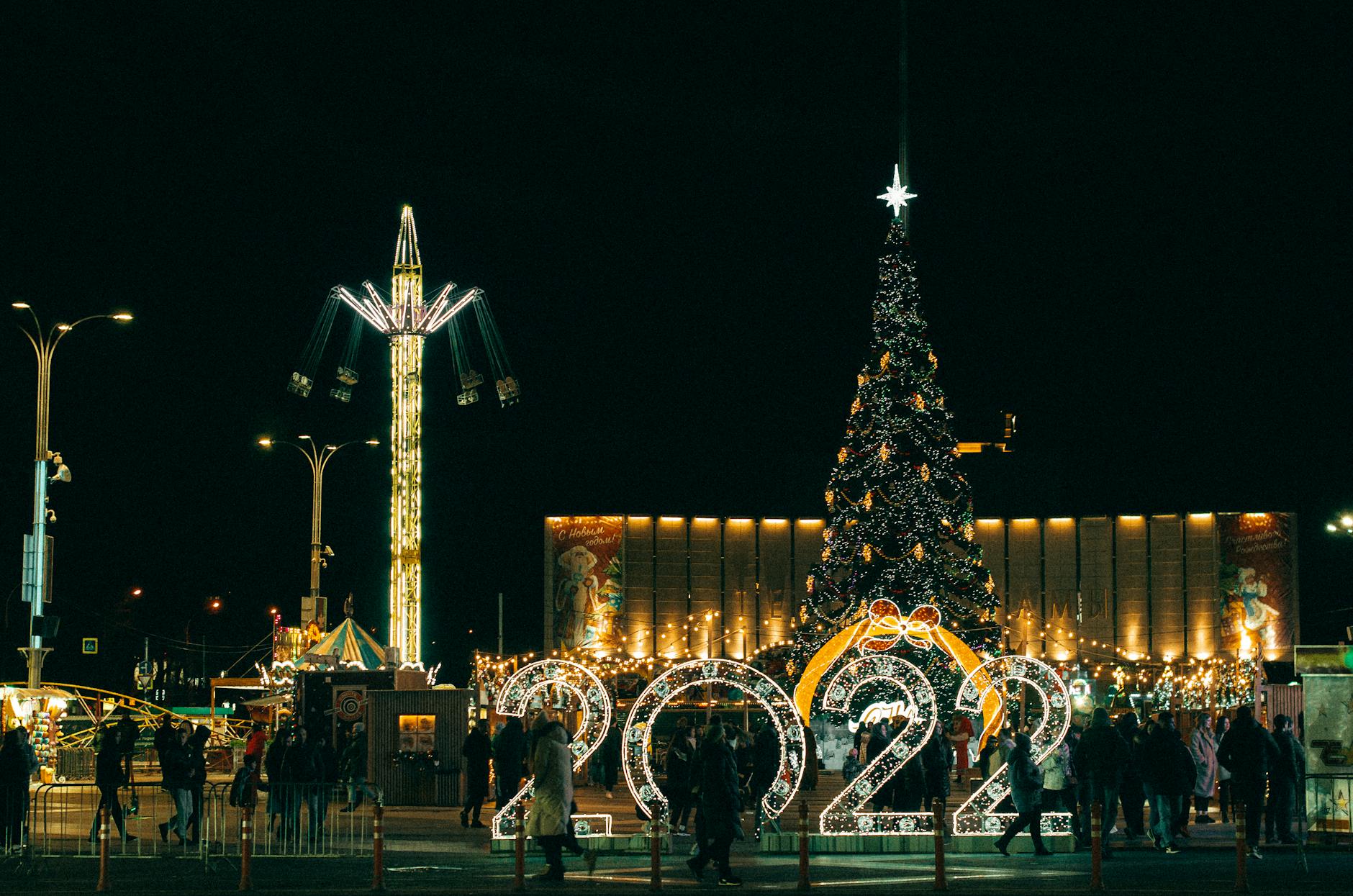 Crowds gathering near a holiday parade and Christmas tree at an Orlando theme park during the busy holiday season