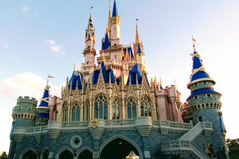 Cinderella Castle at Magic Kingdom in its pink, blue and gold paint scheme with guests below