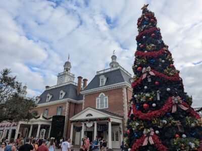 A tall decorated Christmas tree beside the American Adventure pavilion at EPCOT