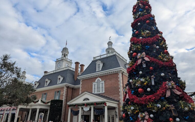 A tall decorated Christmas tree beside the American Adventure pavilion at EPCOT