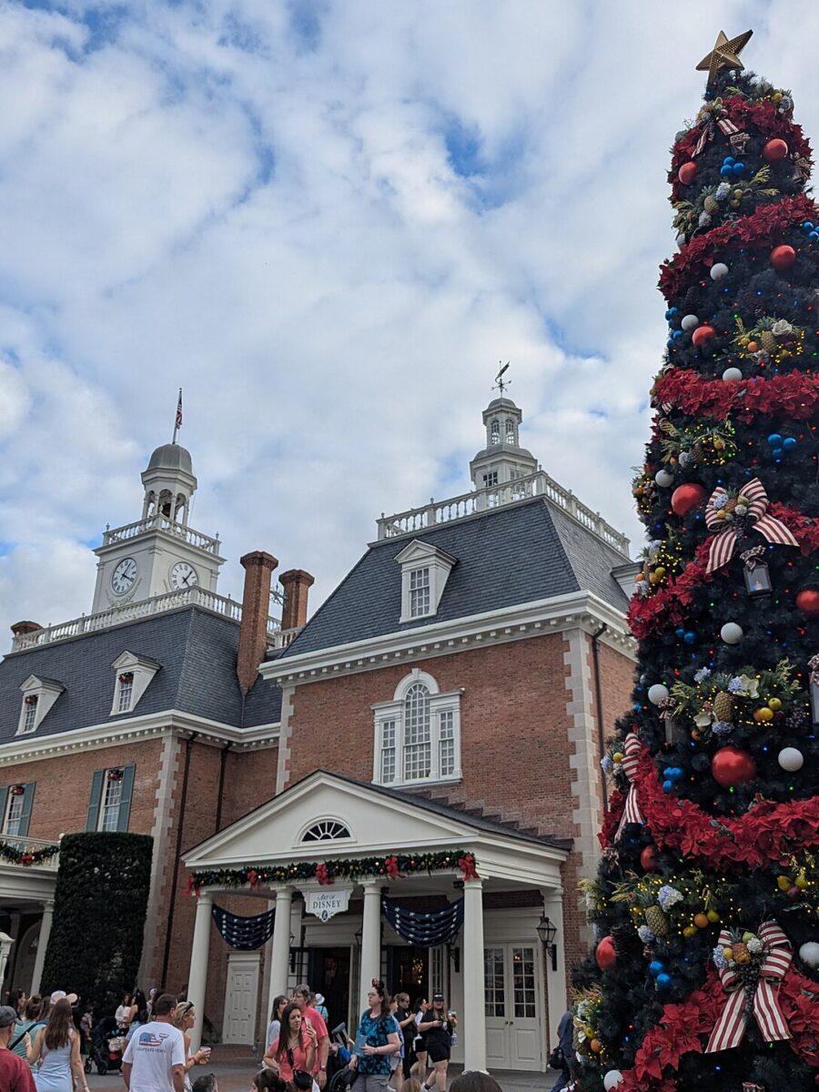 A tall decorated Christmas tree beside the American Adventure pavilion at EPCOT