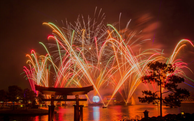 Fireworks exploding over World Showcase Lagoon at EPCOT, framed by the torii gate at the Japan pavilion