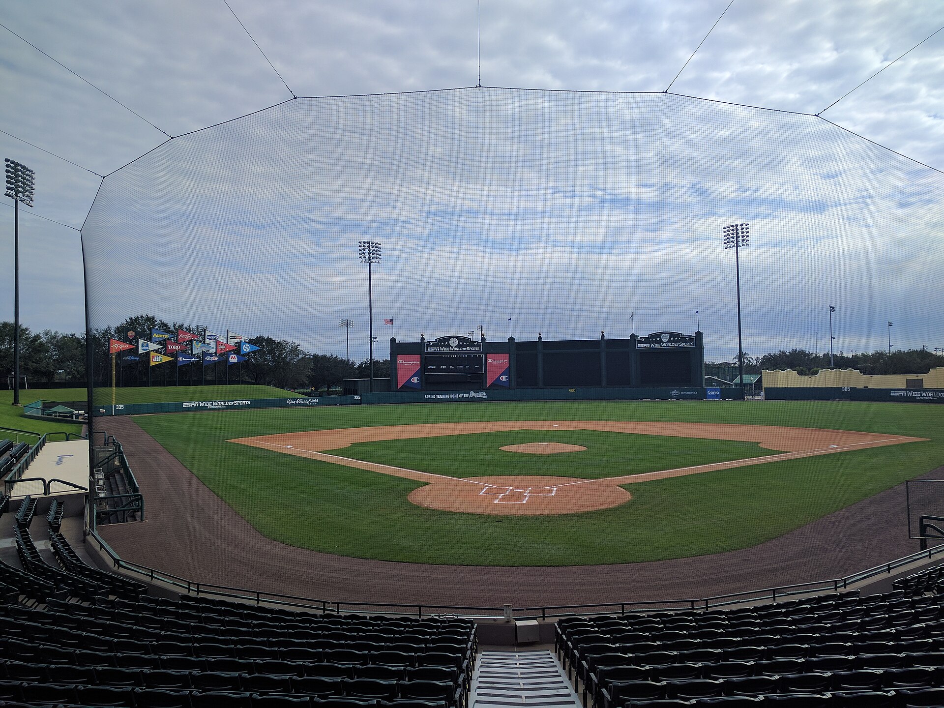 Baseball stadium at ESPN Wide World of Sports with empty green seating and pennant flags beyond the outfield