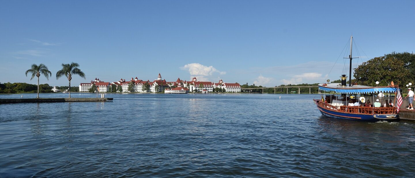 Disney's Grand Floridian Resort seen across Seven Seas Lagoon with a motor launch in the foreground