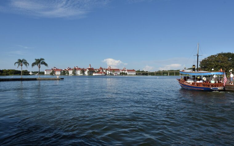 Disney's Grand Floridian Resort seen across Seven Seas Lagoon with a motor launch in the foreground