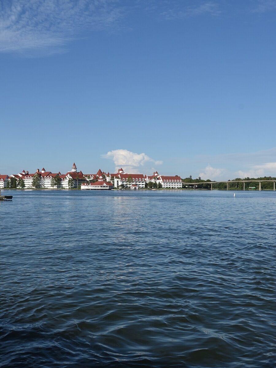 Disney's Grand Floridian Resort seen across Seven Seas Lagoon with a motor launch in the foreground
