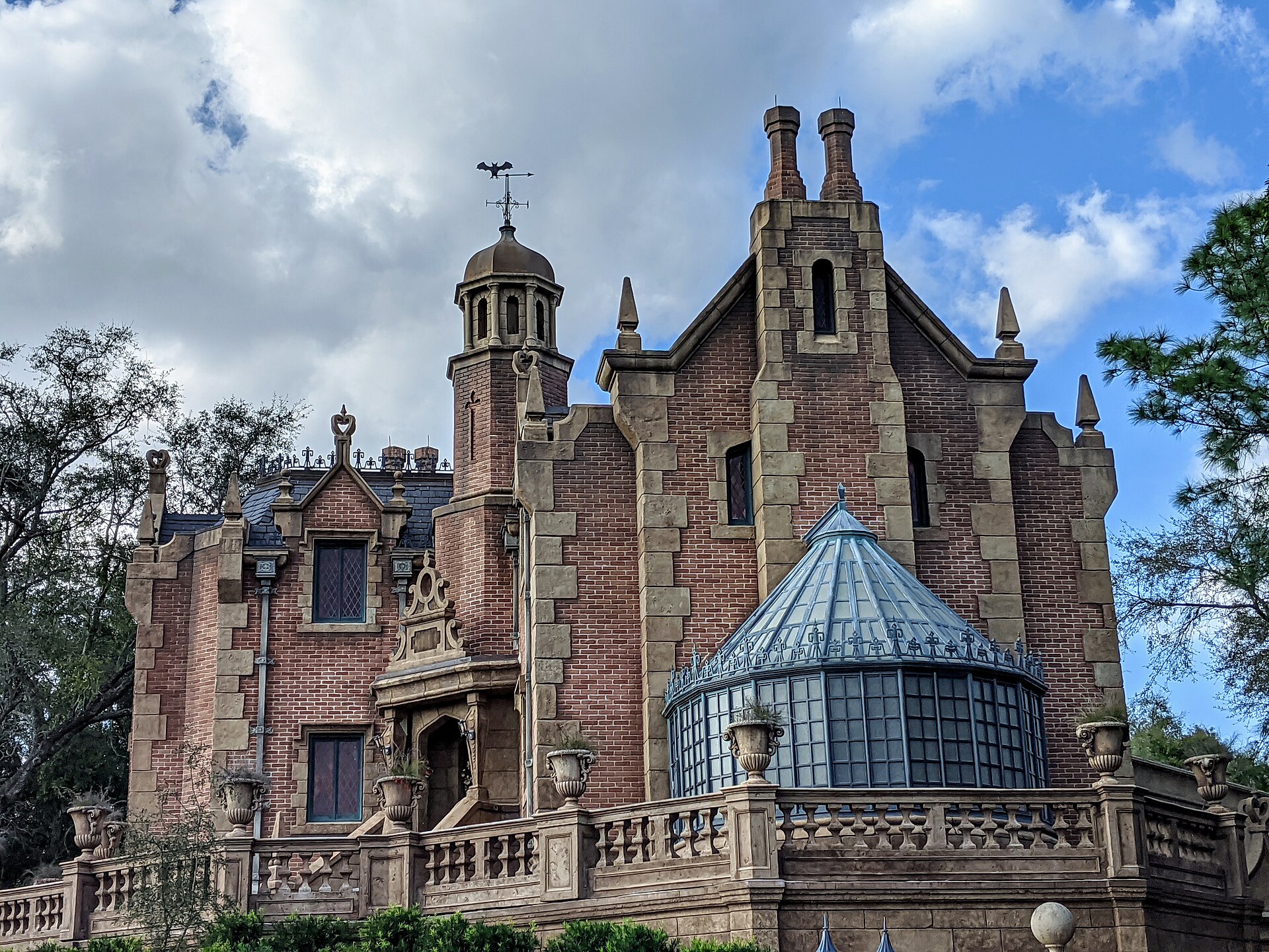The brick facade of the Haunted Mansion at Magic Kingdom with its bat weathervane