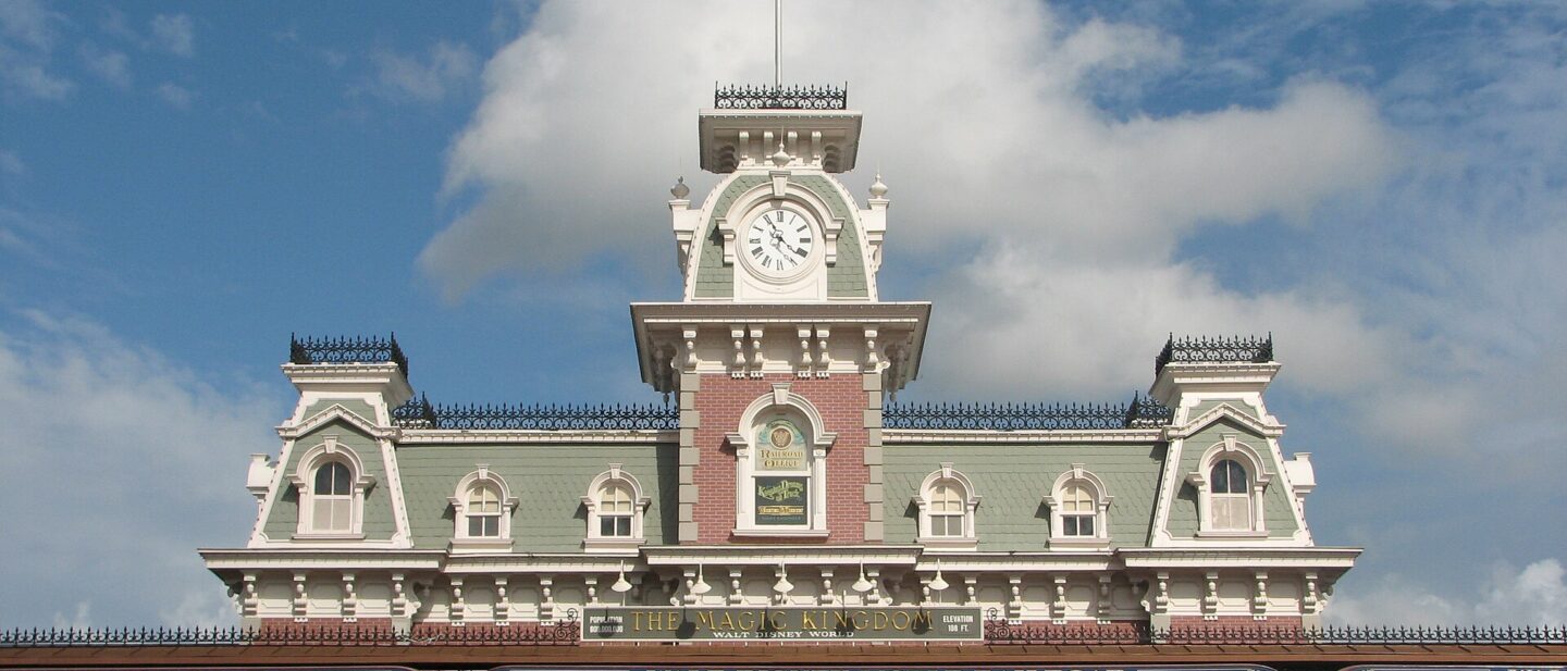 The Main Street Station building at the entrance to Magic Kingdom, with its clock tower and flagpole