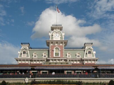 The Main Street Station building at the entrance to Magic Kingdom, with its clock tower and flagpole