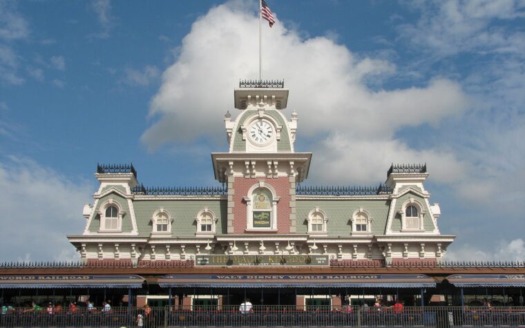 The Main Street Station building at the entrance to Magic Kingdom, with its clock tower and flagpole