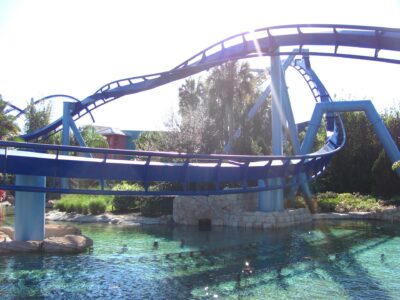 Blue track of the Manta flying coaster curving low over a clear lagoon at SeaWorld Orlando