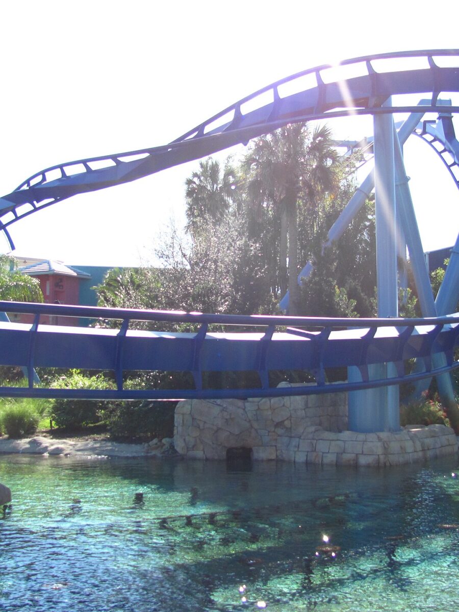 Blue track of the Manta flying coaster curving low over a clear lagoon at SeaWorld Orlando
