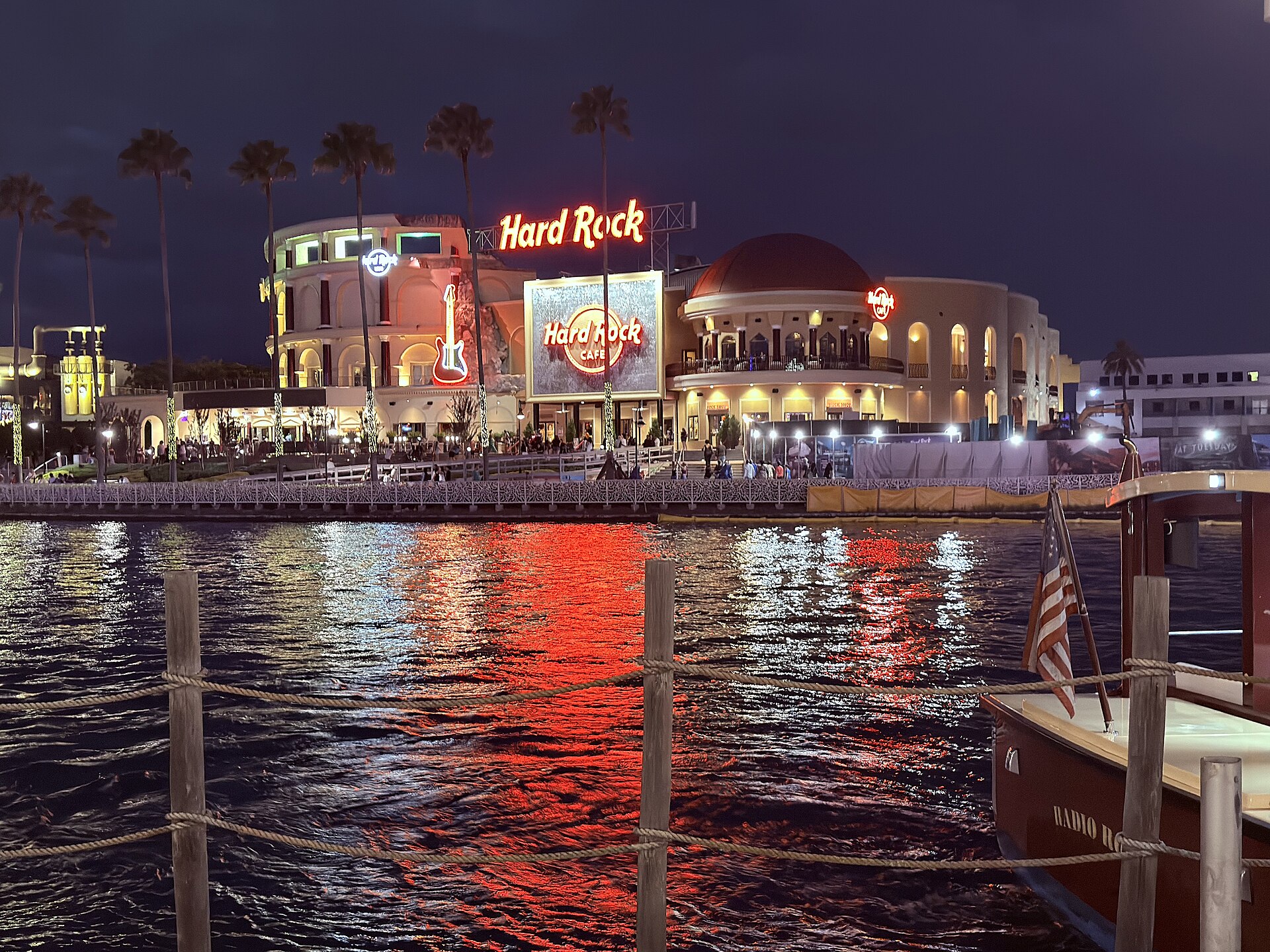 Universal CityWalk lit up at night with the Hard Rock Cafe reflected in the water