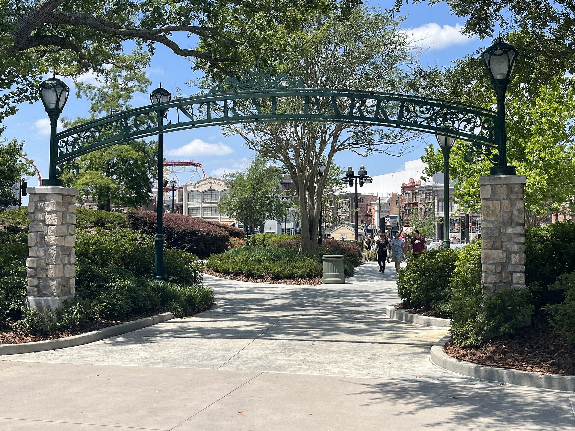 Wrought-iron Central Park arch with lampposts and shaded paths at Universal Studios Florida