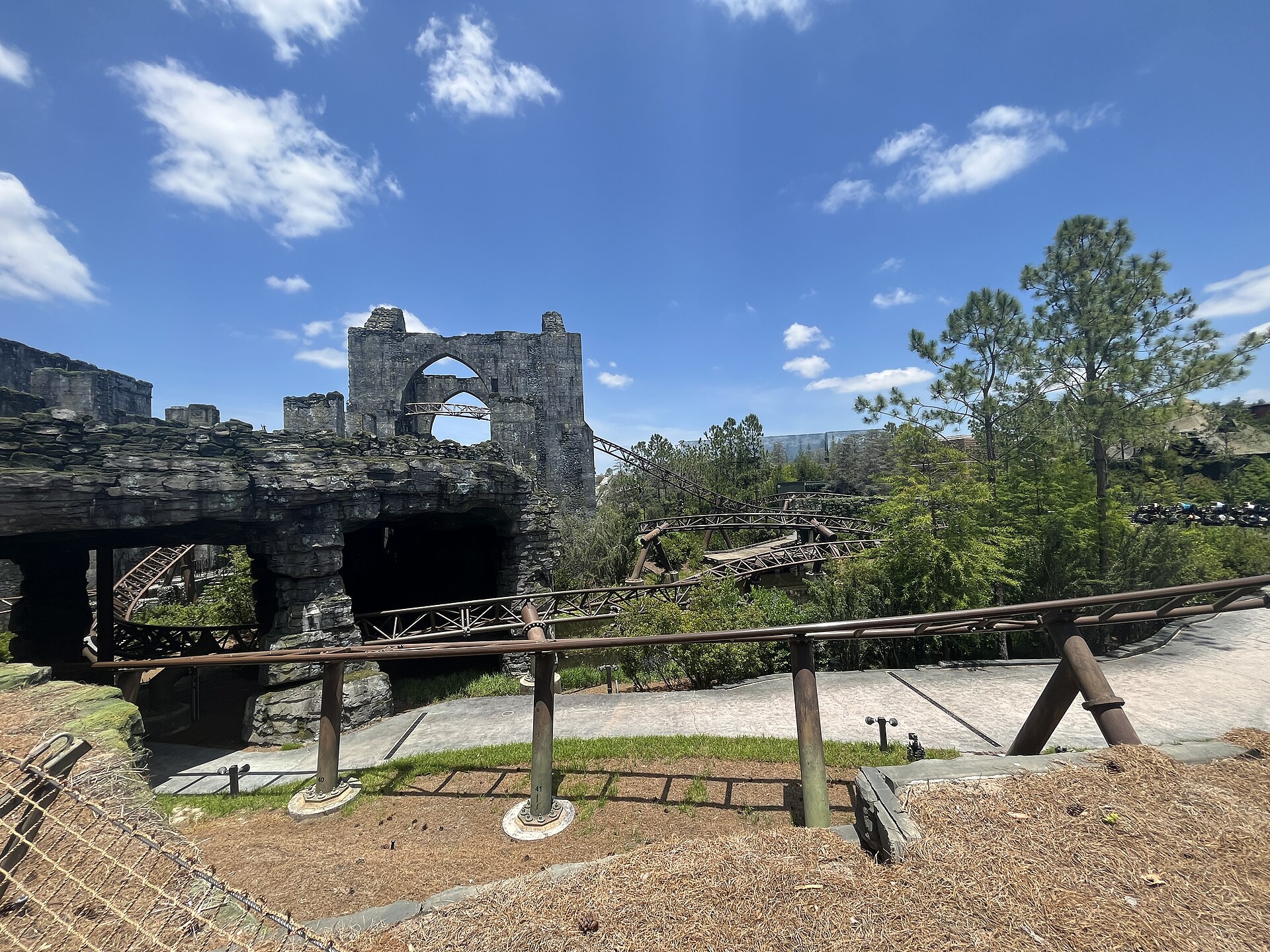 The brown track of Hagrid's Magical Creatures Motorbike Adventure winding through trees and around stone ruins at Islands of Adventure