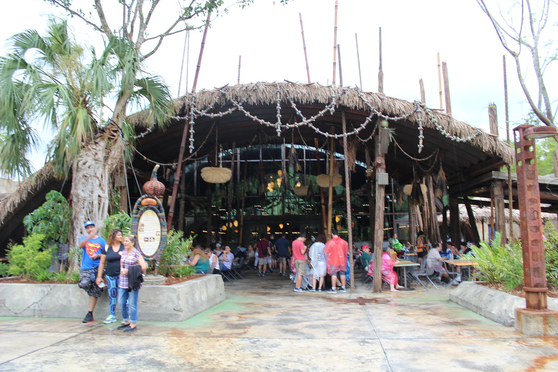 The thatched entrance of Satu'li Canteen in Pandora at Disney's Animal Kingdom, with guests eating at tables under the canopy